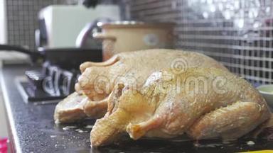 在厨房餐桌上用草药和香料生整只火鸡。